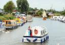 People enjoying a boating holiday along the Broads.