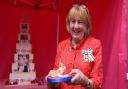 The Lady Dannatt MBE cuts the special six tier cake in Holt for the Queen's Platinum Jubilee earlier this year