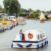 People enjoying a boating holiday along the Broads.