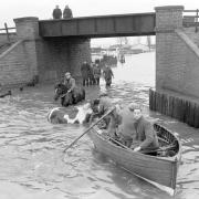 People row a boat in floodwaters in Cobholm in Great Yarmouth in 1953.