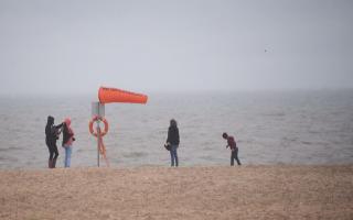 A family on the empty beach as the wind and rain hits Great Yarmouth sea front. Picture: DENISE BRADLEY