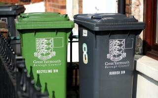 A green recycling wheelie and bin and a black rubbish bin outside a home in Great Yarmouth.